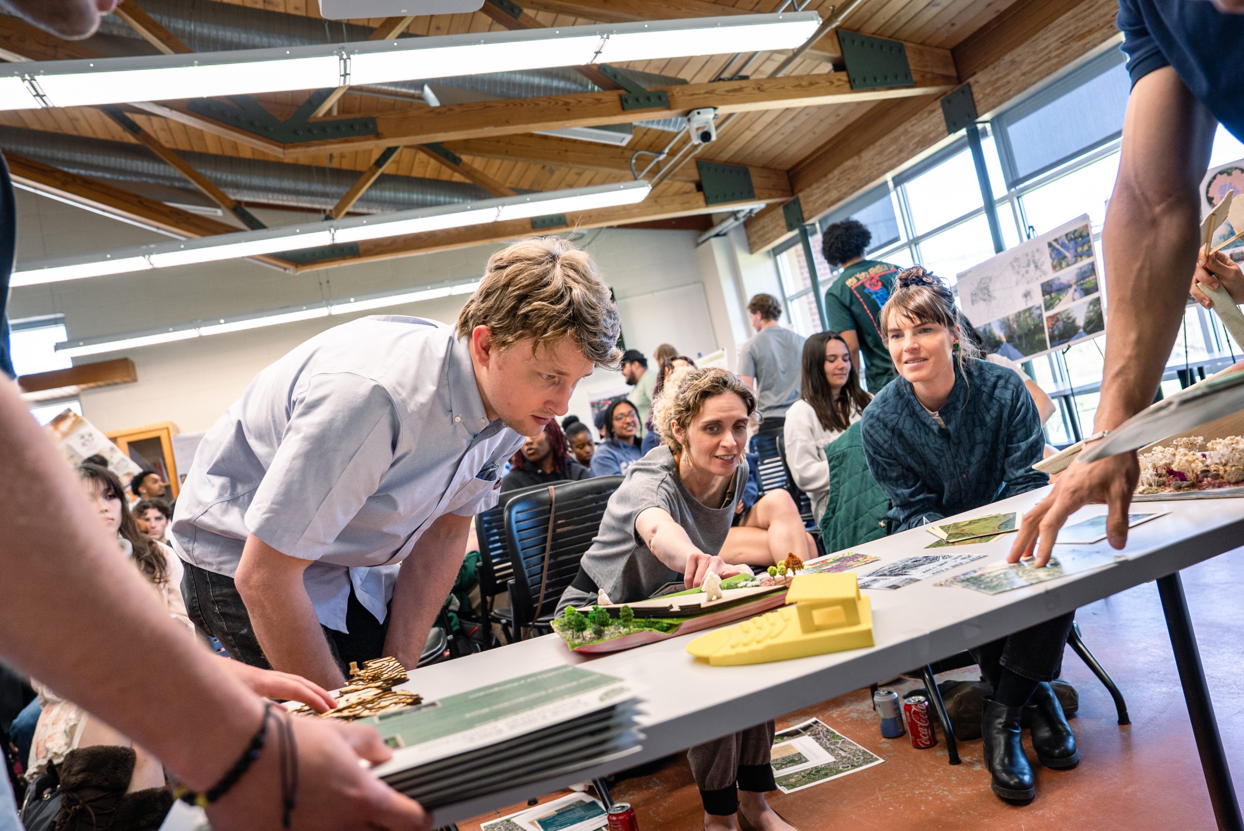 LA students and professors around a table full of models