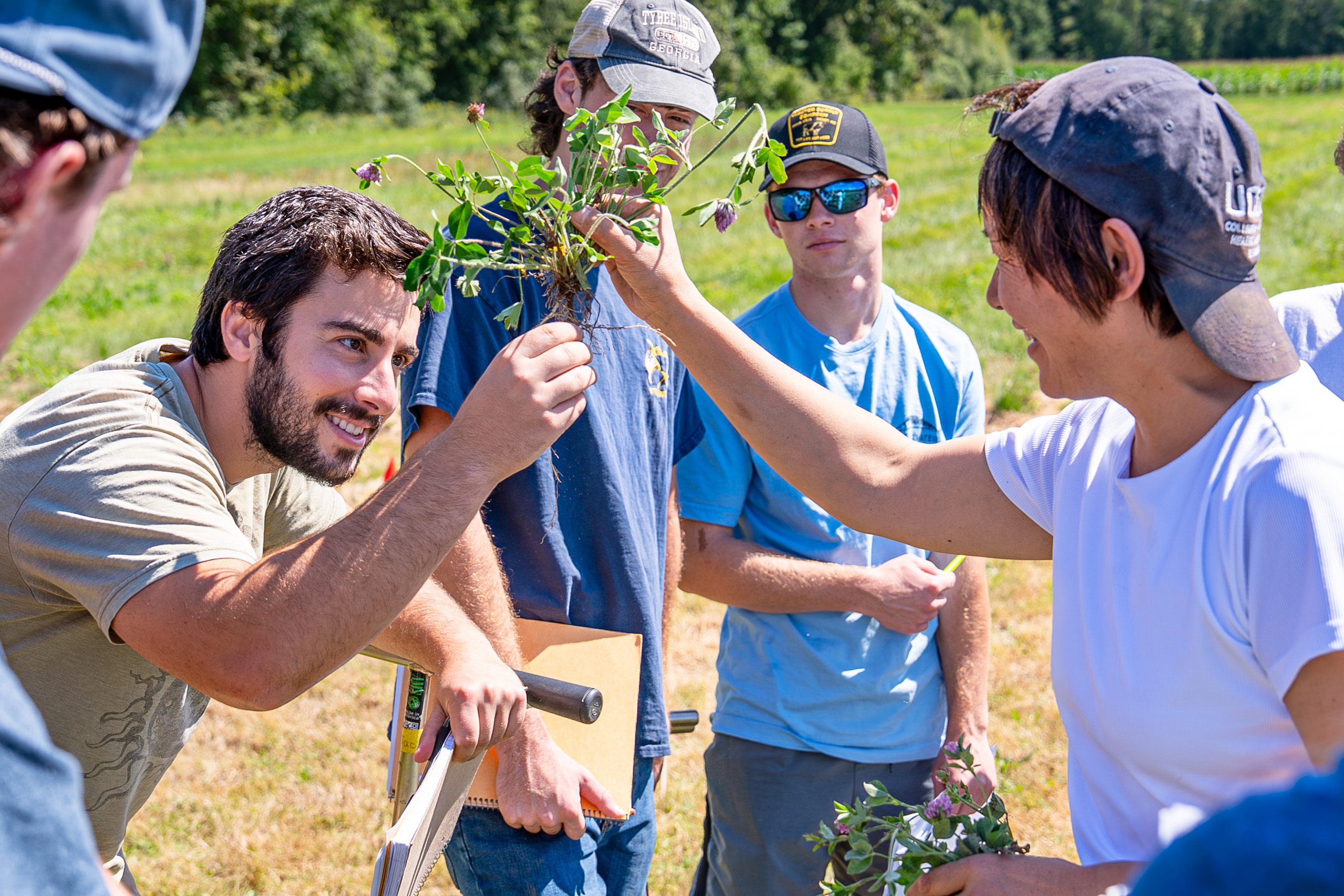 students and a professor looking at soil samples and roots