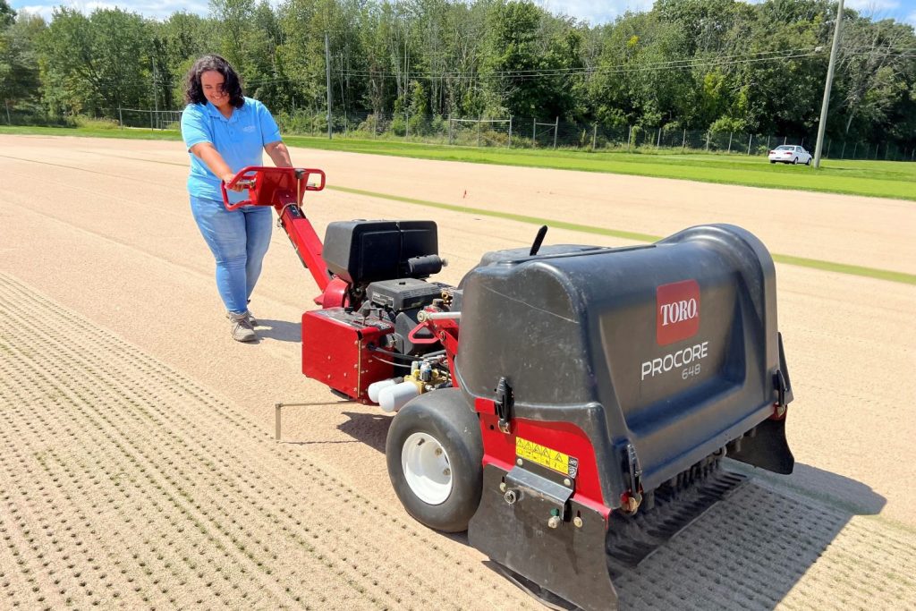brianna callazo behind a large agricultural machine