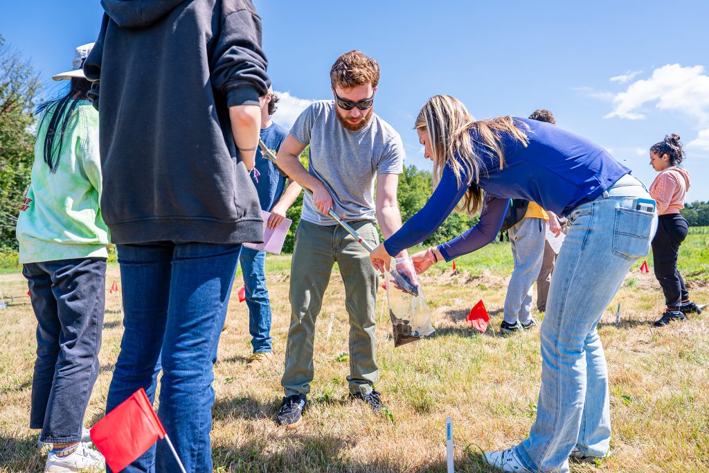 students collecting and bagging soil samples in the field